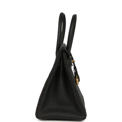Black leather handbag with dual top handles and gold hardware clasp detail