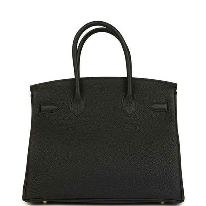 Black leather handbag with embossed front panels and top handles