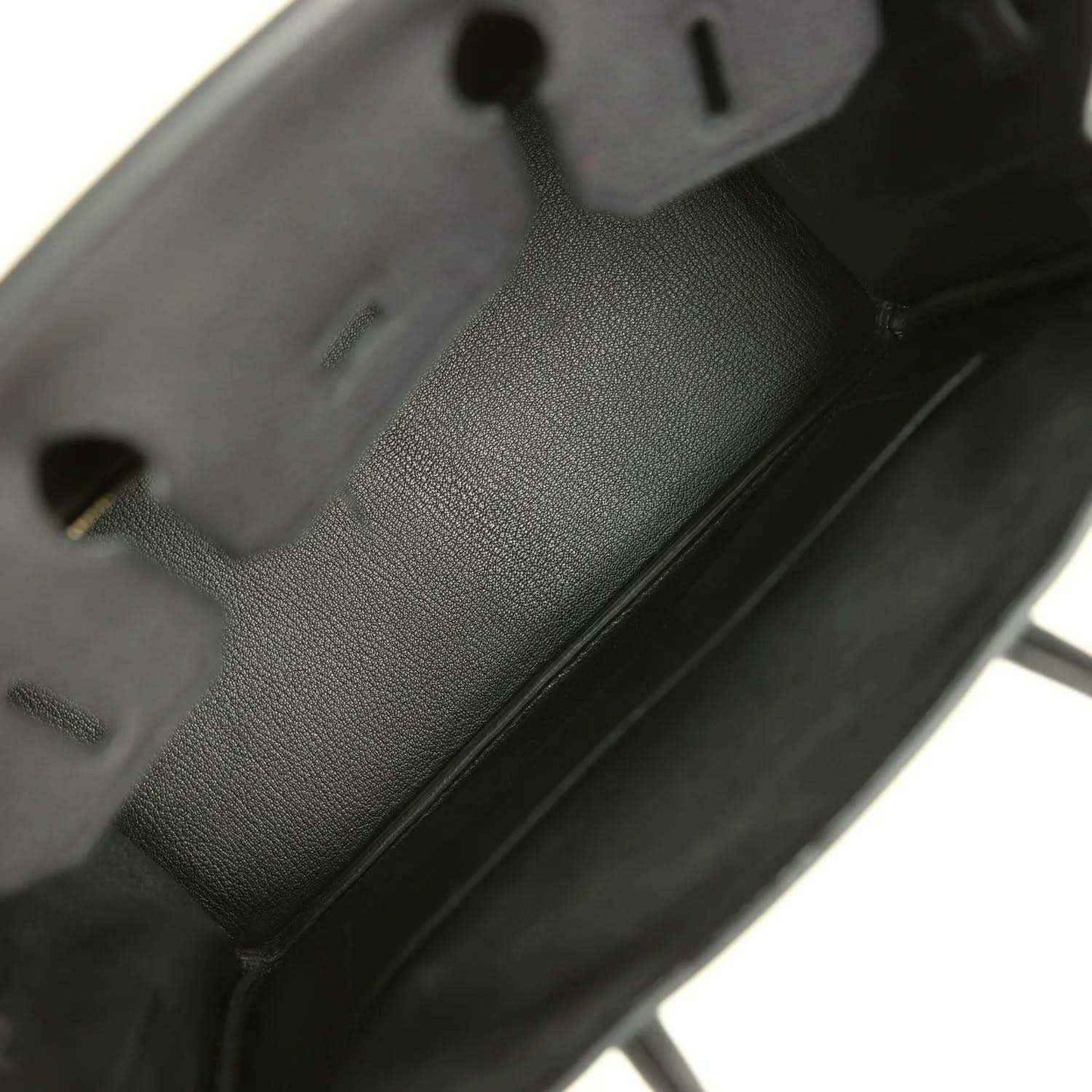 Black leather handbag interior with embossed logo patch and compartments