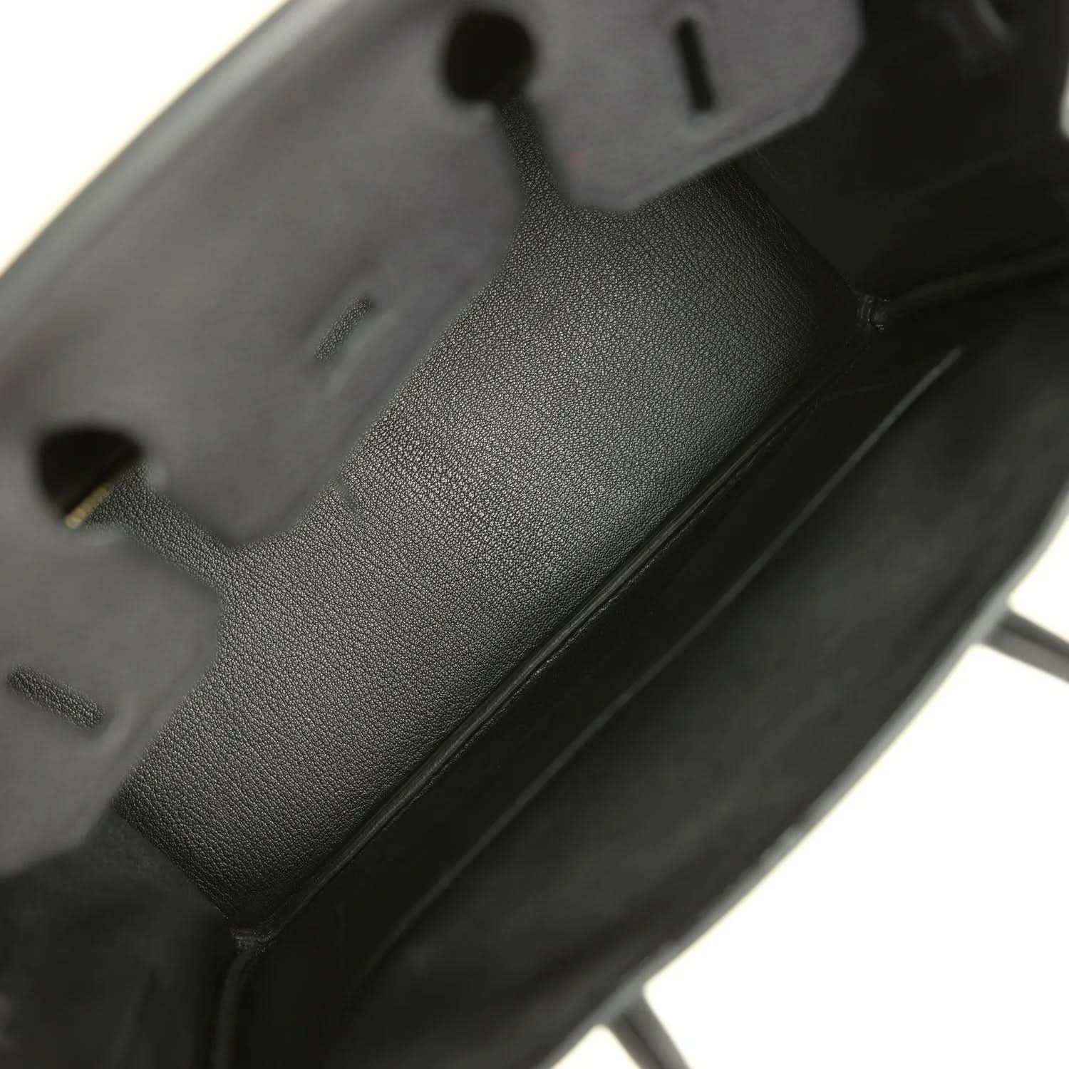 Black leather handbag interior with embossed logo patch and compartments