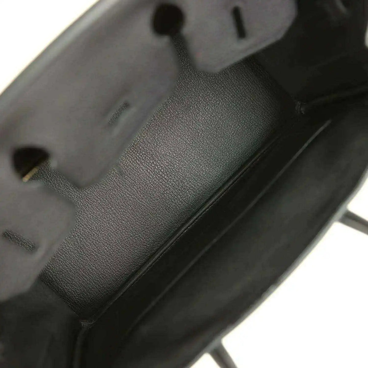 Black leather handbag interior with embossed logo patch and compartments