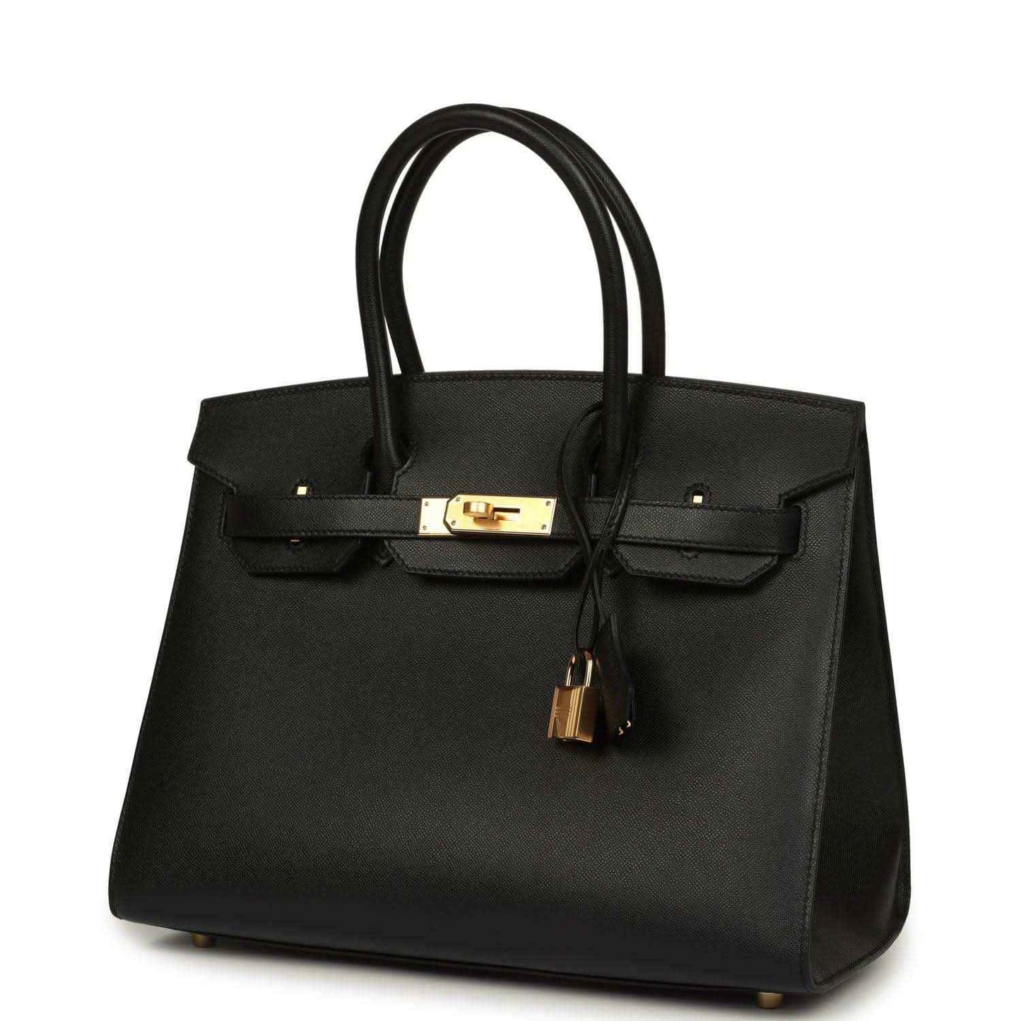Black leather handbag with top handles, gold front clasp, and hanging tassel