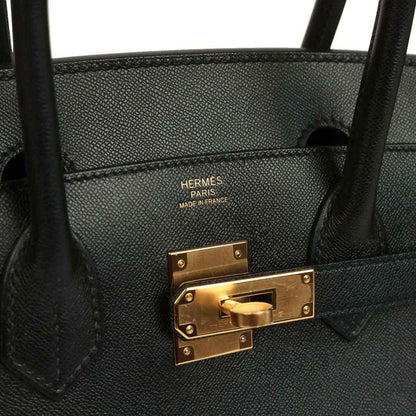 Black leather handbag interior with “HERMES PARIS MADE IN FRANCE” and gold clasp