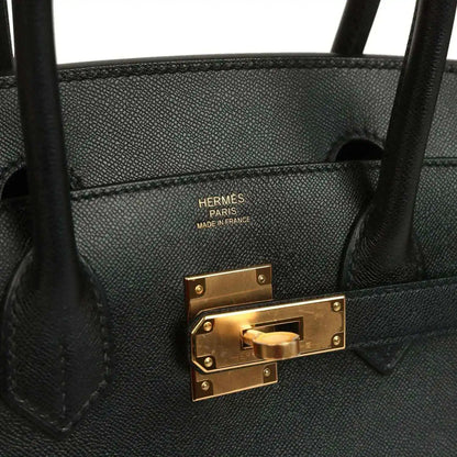 Black leather handbag interior with “HERMES PARIS MADE IN FRANCE” and gold clasp