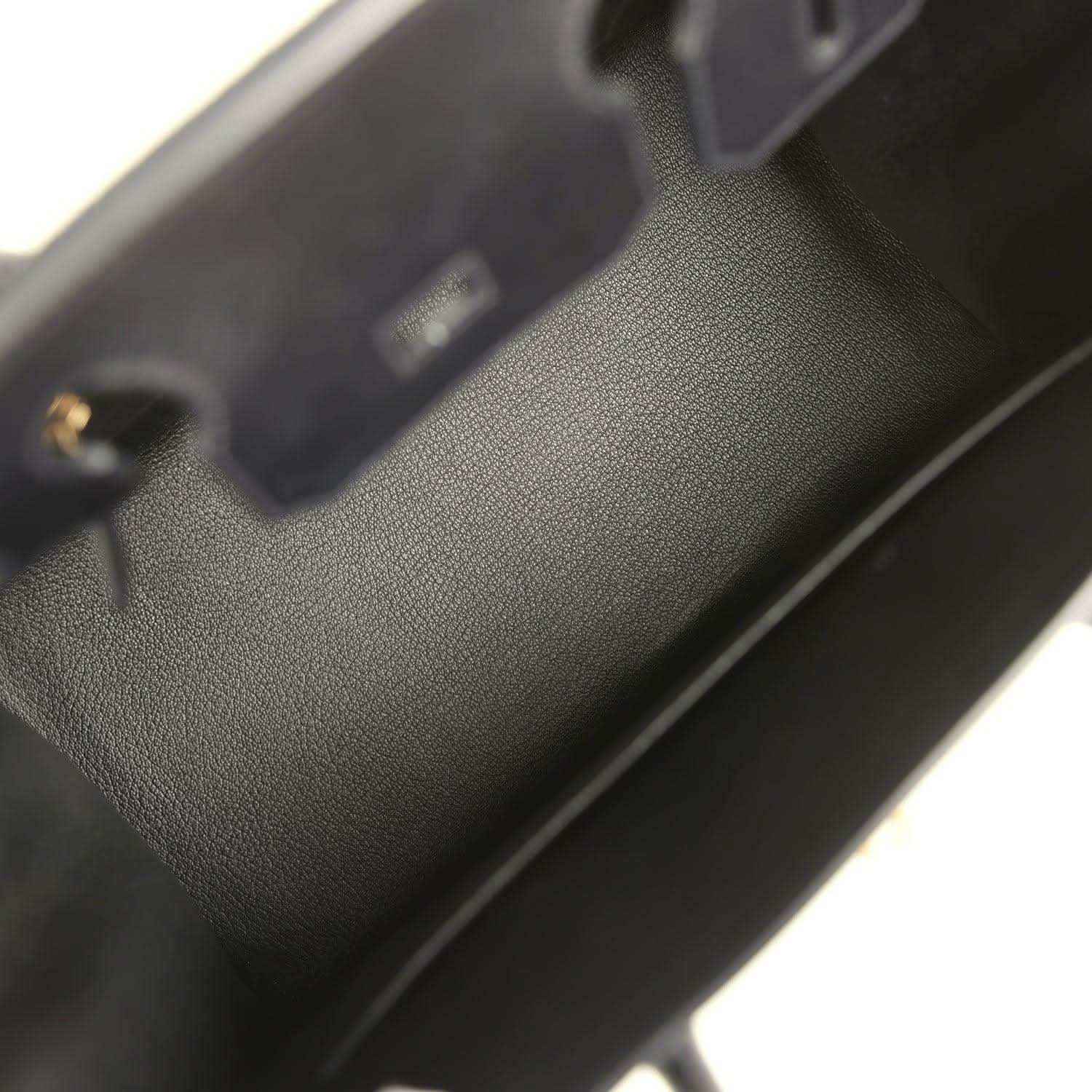Black leather handbag interior with stitched edge and small gold hardware detail
