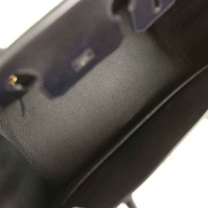 Black leather handbag interior with stitched edge and small gold hardware detail