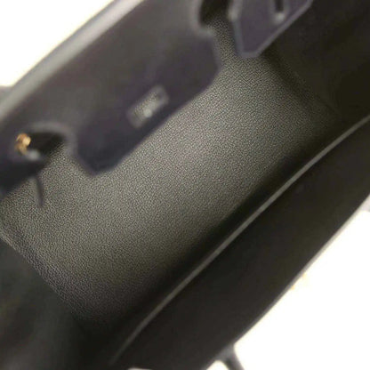 Black leather handbag interior with stitched edge and small gold hardware detail