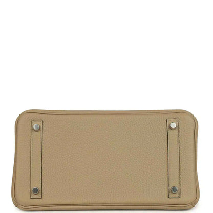 Tan leather handbag base view with reinforced corners and two side hardware tabs