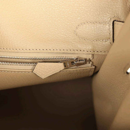 Tan leather handbag interior with zipper track and metal zipper pull