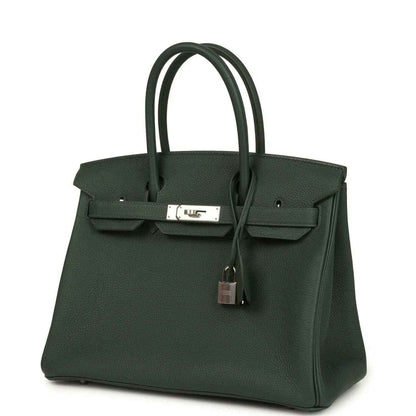 Green leather handbag with top handles, front flap closure and hanging padlock charm