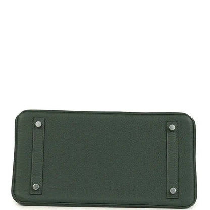 Green leather handbag base with stitched panels and four small metal feet