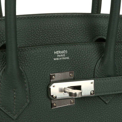 Green leather handbag interior label and turn-lock clasp with silver hardware