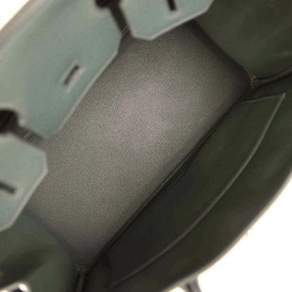 Green leather handbag interior with smooth lining and stitched corner seams
