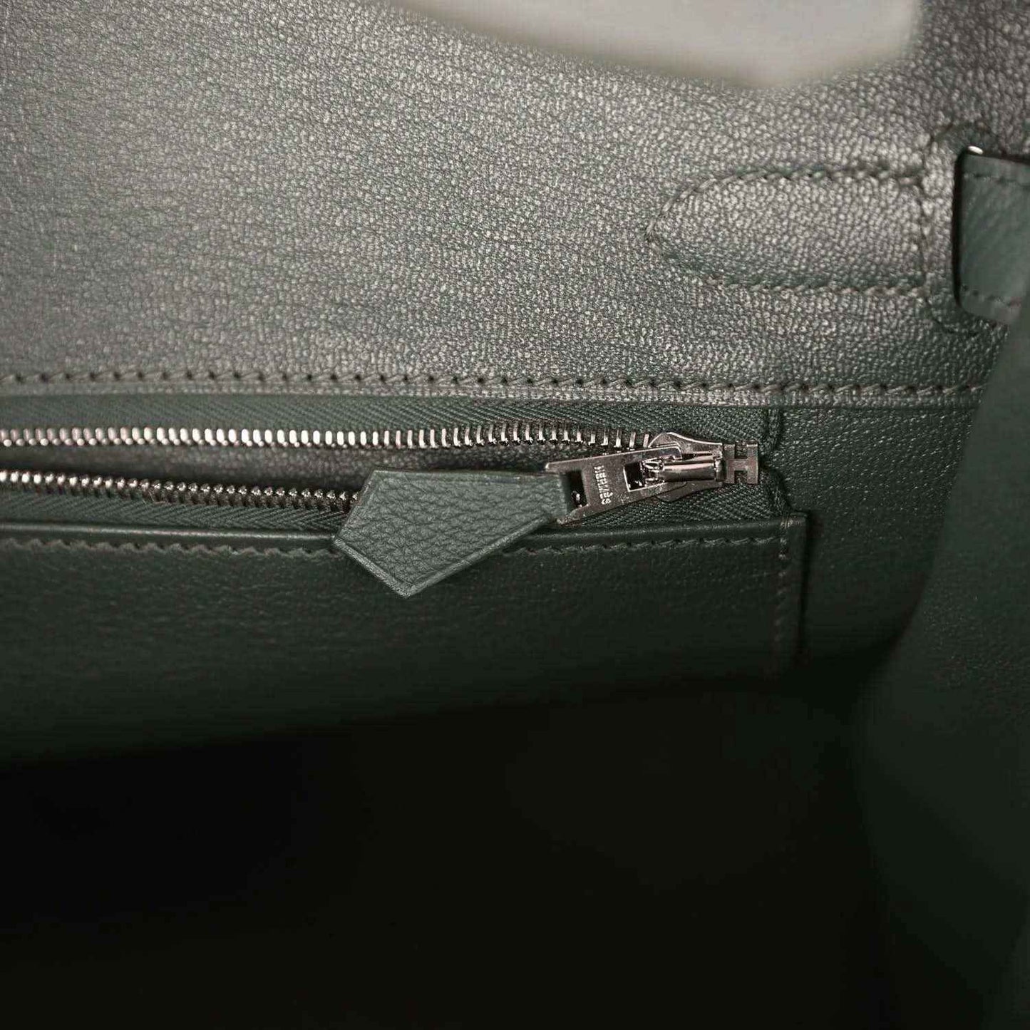 Green leather handbag interior pocket with zipper and metal pull tab