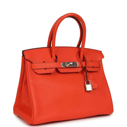 Orange Birkin handbag, front view with textured leather, top handles, and hanging padlock