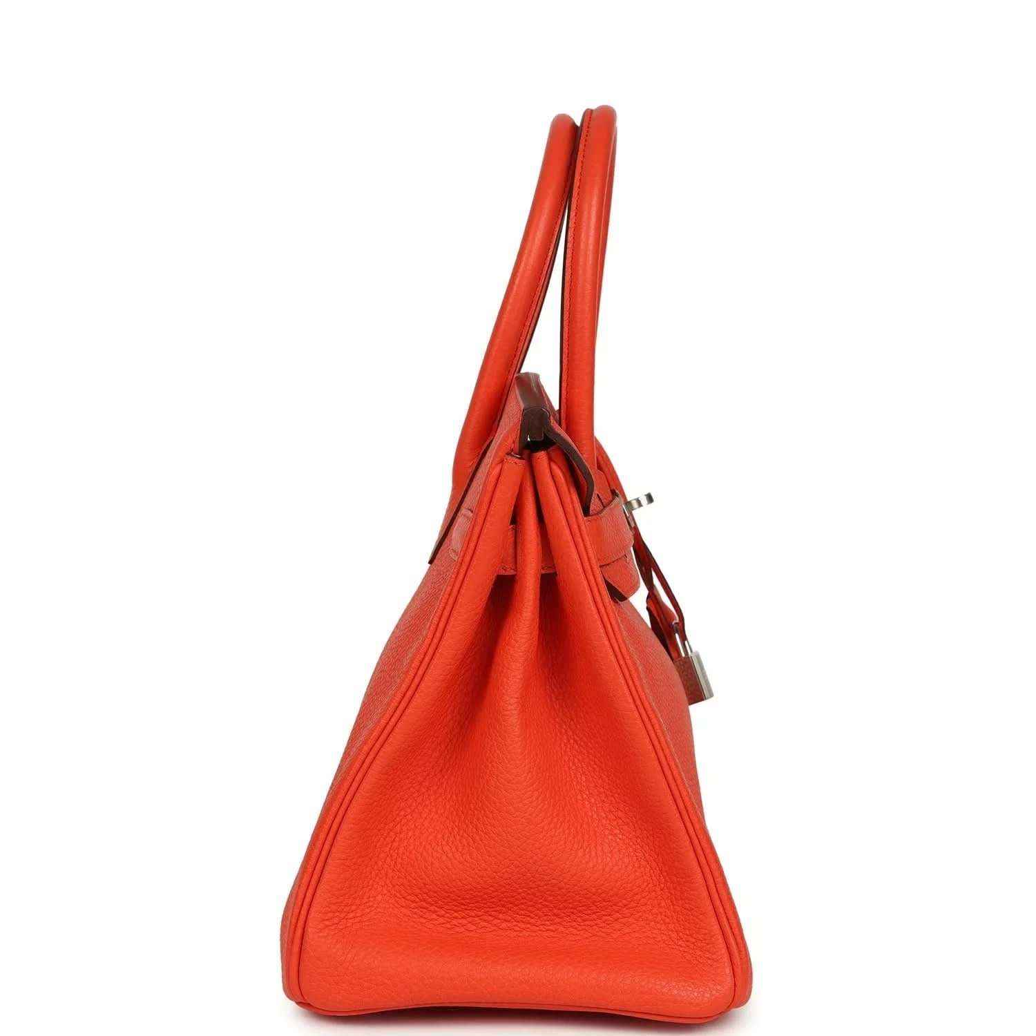 Orange Birkin handbag side view with textured leather, top handles, and hanging lock