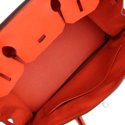 Orange Birkin handbag interior view with textured lining and partial flap hardware