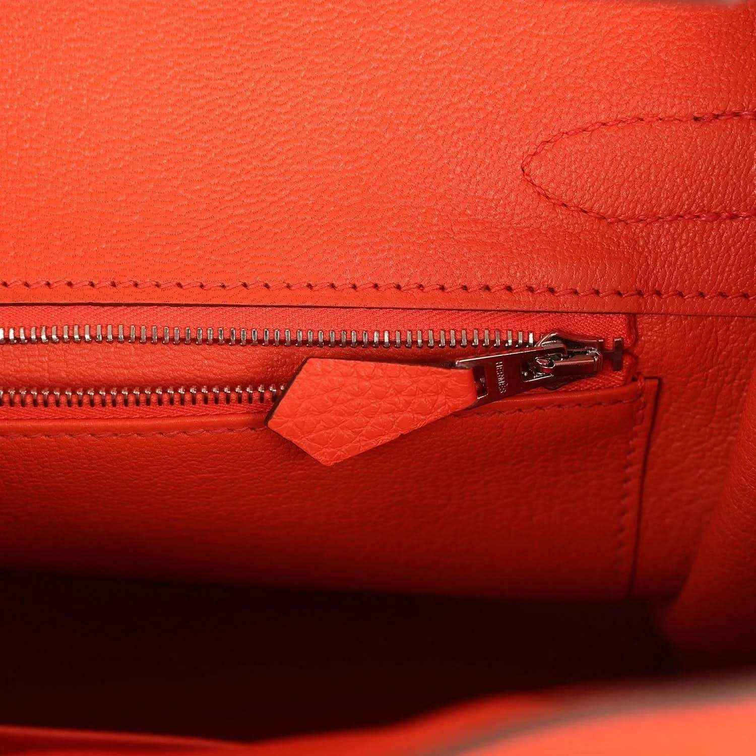Orange handbag close-up of zipper and leather pocket with stitched edging and hardware