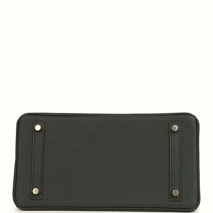 Dark green leather pouch with corner metal studs and centered seam