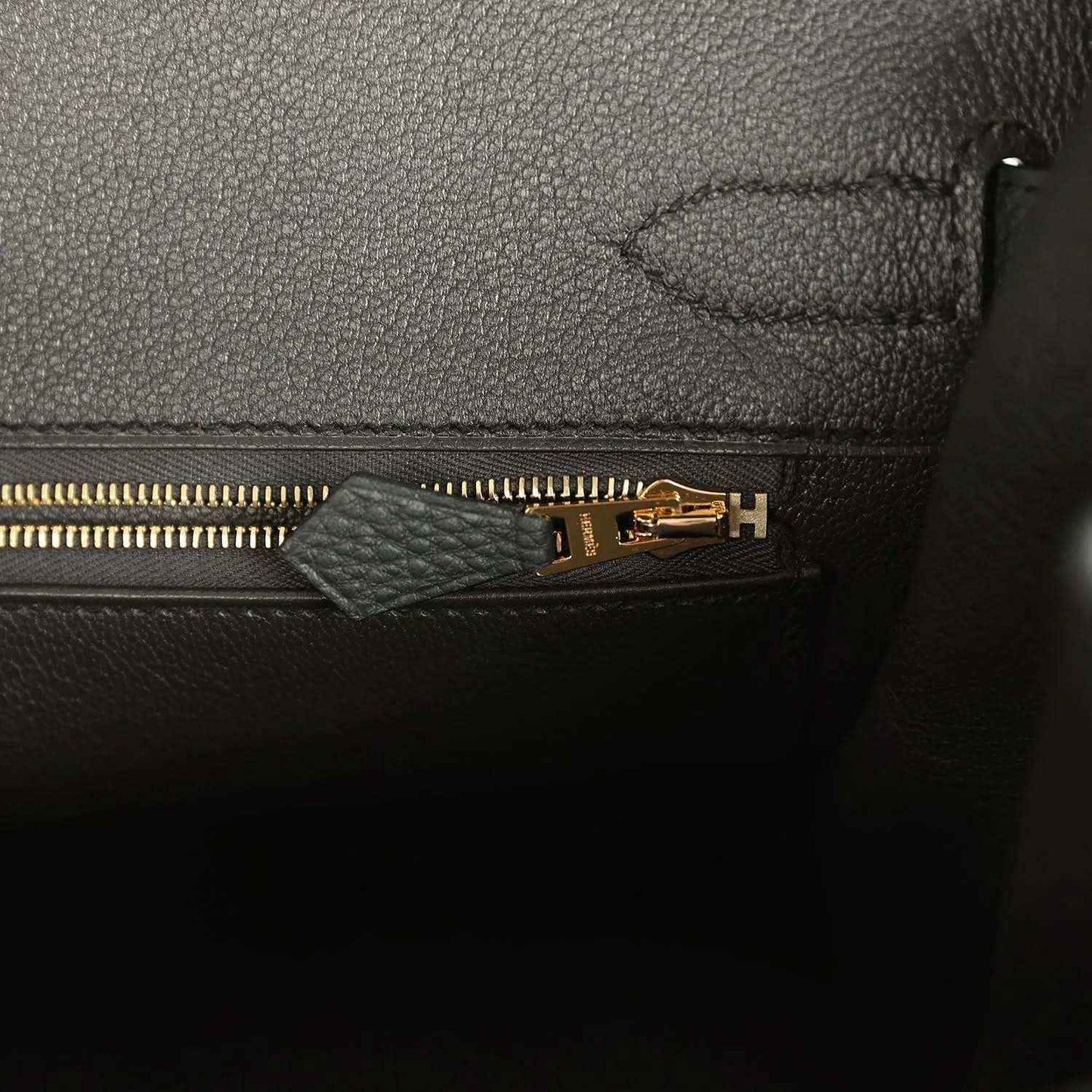 Dark green leather interior with gold zipper and stitched seam