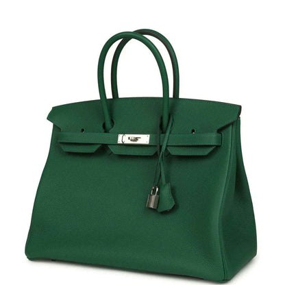 Green leather handbag with top handles, front flap, and silver-tone lock with charm