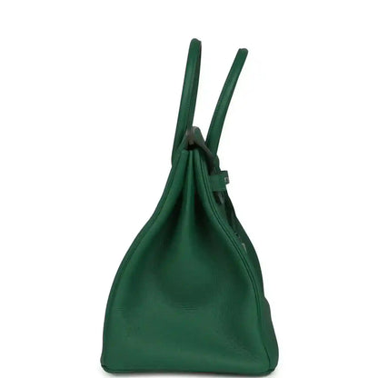 Green leather handbag with tall top handles and cinched opening at the upper edge
