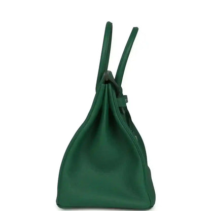 Green leather handbag with tall top handles and cinched opening at the upper edge