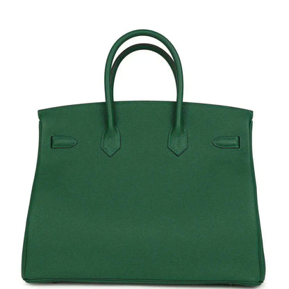 Green leather handbag with top handles and contrast stitching on front panels