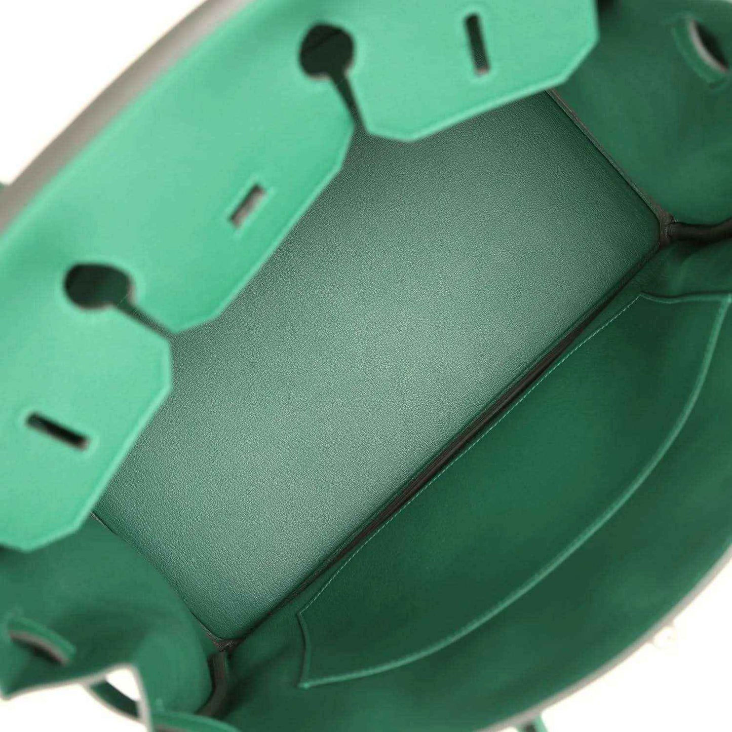 Green leather handbag interior with stitched panels and compartment dividers