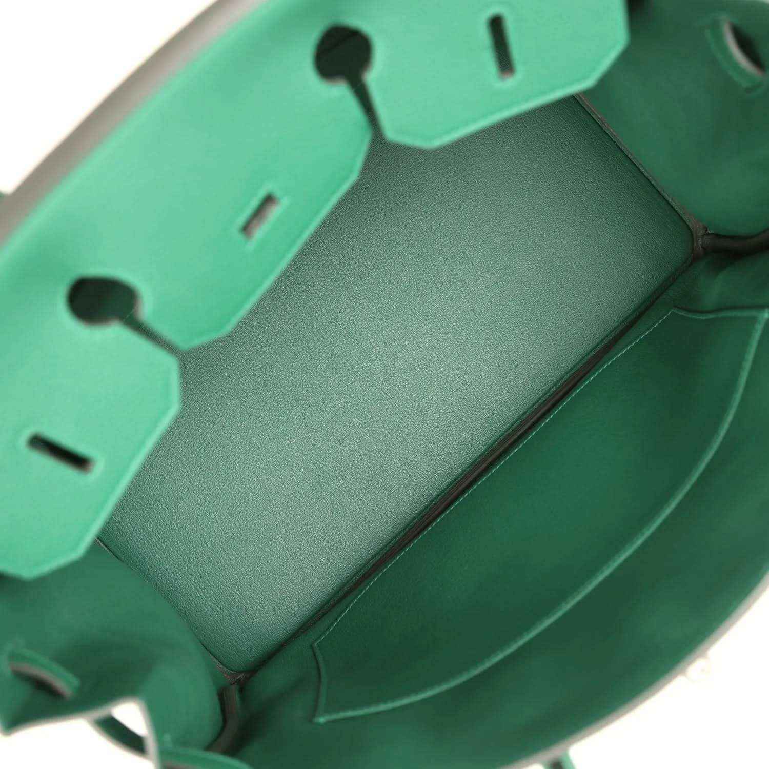 Green leather handbag interior with stitched panels and compartment dividers