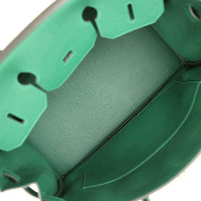 Green leather handbag interior with stitched panels and compartment dividers