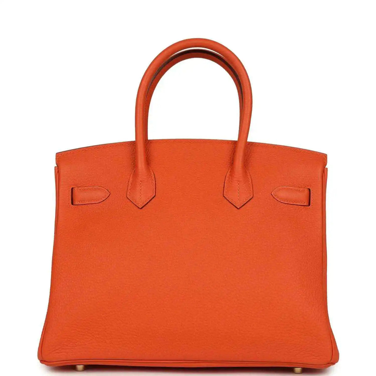 Orange leather handbag back view with two top handles and minimal front hardware.