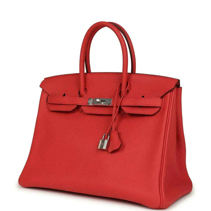 Red leather handbag with top handles, front flap pockets, and silver-tone padlock
