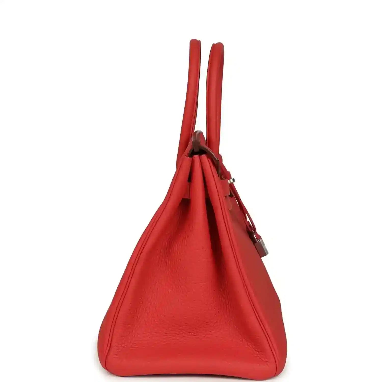 Red leather handbag with two top handles and side lock hardware, side view