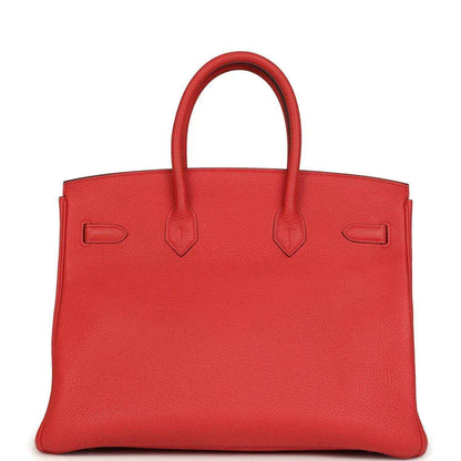 Red leather handbag with structured panels and top handles, back view
