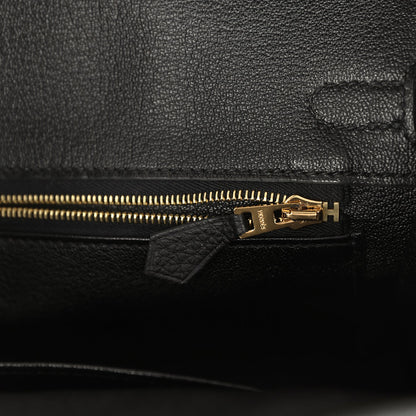 Black leather handbag zipper with gold-tone pull and leather tab