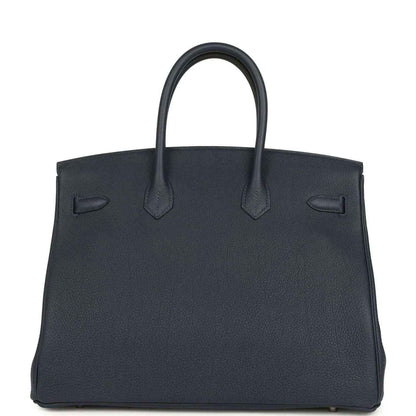 Navy leather handbag with top handles and front flap detail