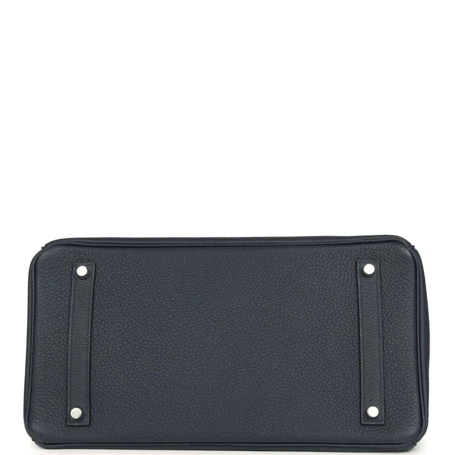 Navy leather handbag front panel with corner studs and top trim