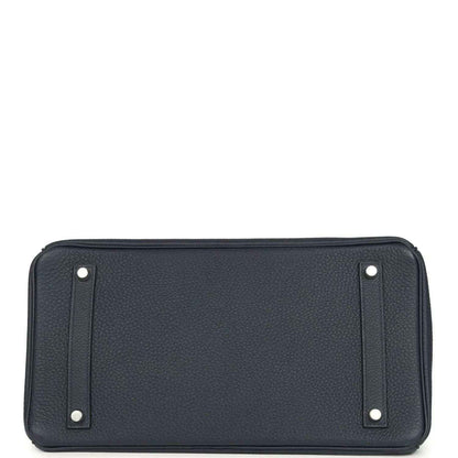 Navy leather handbag front panel with corner studs and top trim