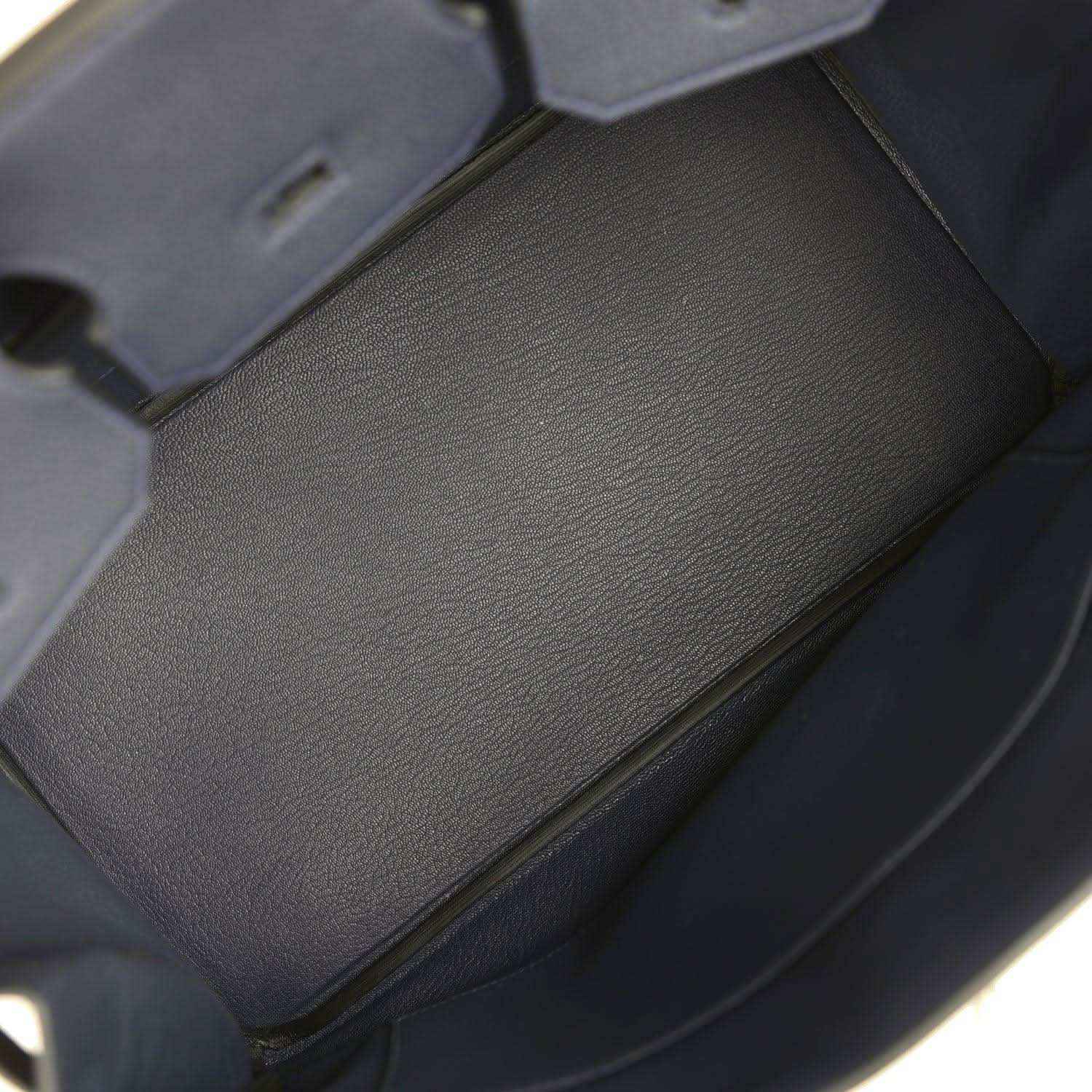 Navy leather interior pocket with stitched edges inside the handbag
