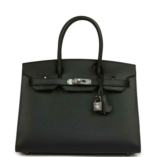 Black leather handbag with top handles, front clasp, and hanging lock charm