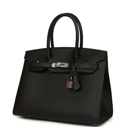 Black leather handbag with front clasp hardware and hanging lock charm