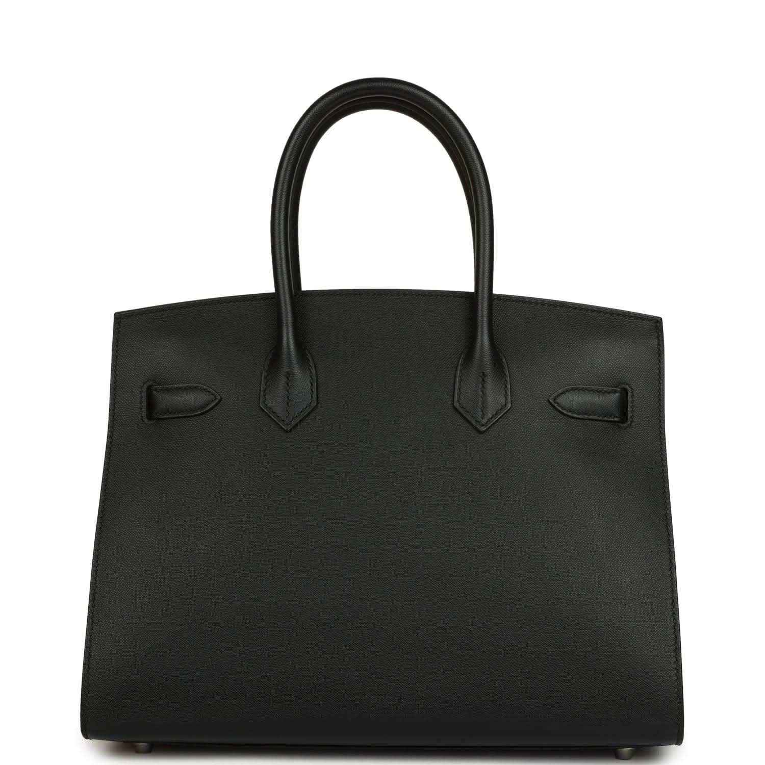 Black leather handbag with top handles and front decorative pocket details
