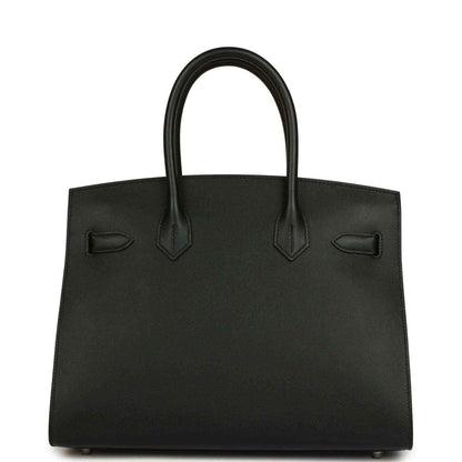 Black leather handbag with top handles and front decorative pocket details