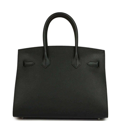 Black leather handbag with top handles and front decorative pocket details