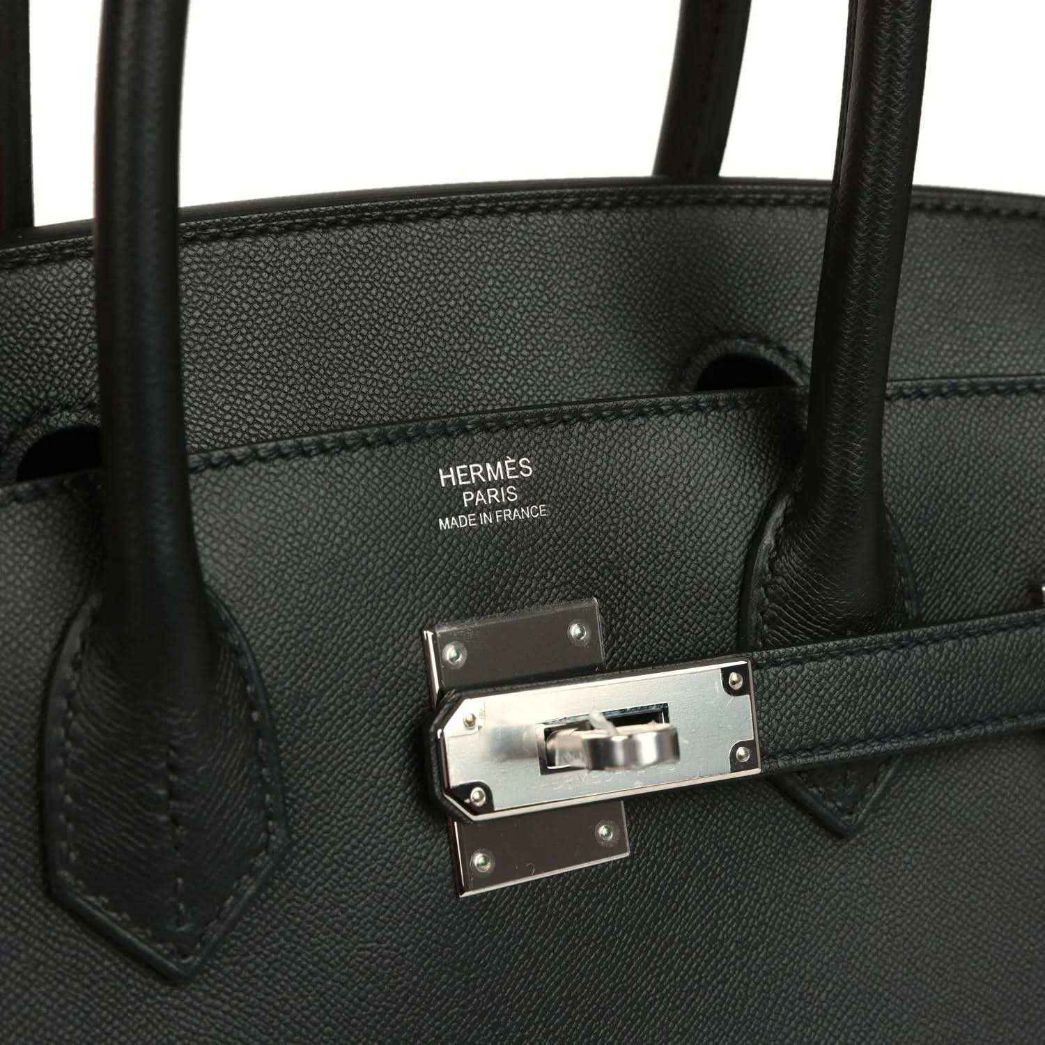 Black leather handbag interior stamp with front clasp hardware and straps