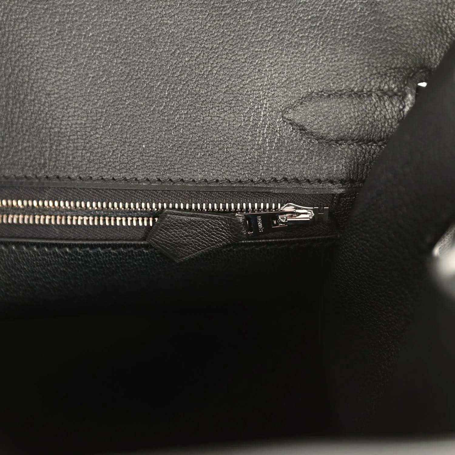 Black leather handbag interior with zipper and stitched fabric lining