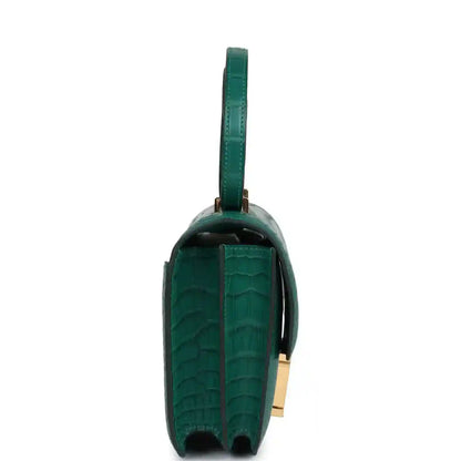 Green alligator-texture handbag side view with leather strap and gold hardware
