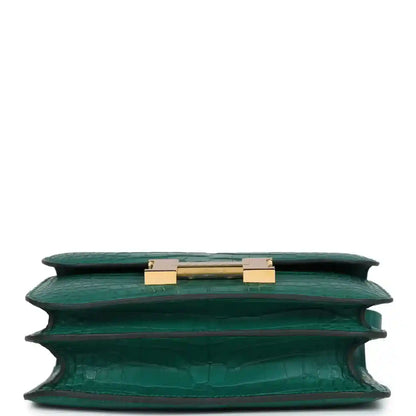 Green alligator-texture handbag top view with open flap and gold turn-lock hardware