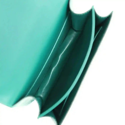 Handbag interior corner with green leather lining and stitched seam